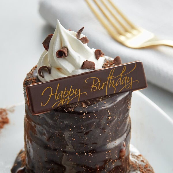 A chocolate cake with whipped cream and a Chocolatree happy birthday sign on top.