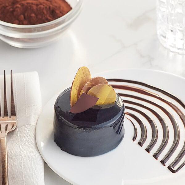 A chocolate cake with cocoa powder on a plate.