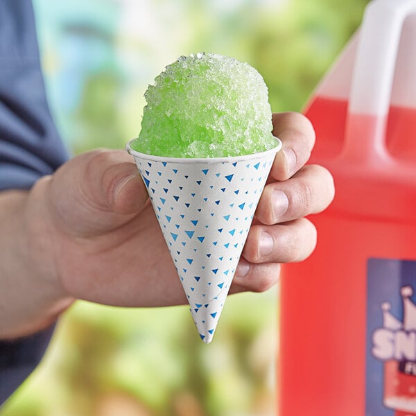 A hand holding a Choice paper cone filled with green snow cone.