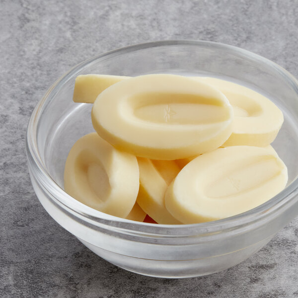 A glass bowl filled with Valrhona Ivoire white chocolate.