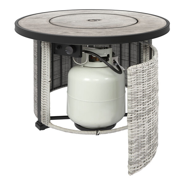 A 36" round stainless steel LP gas fire pit with a white propane cylinder on a table.