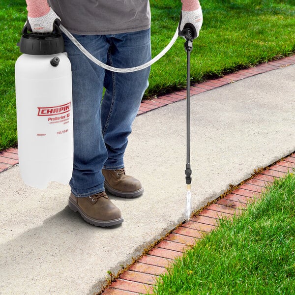 A man using a Chapin Pro Series multi-purpose sprayer to spray a lawn.