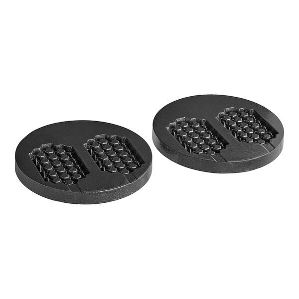 A pair of black circular rubber pads with hexagons on them.