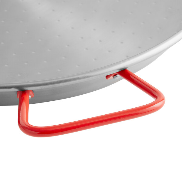A close up of a Vigor 8" Polished Carbon Steel Paella Pan with a red handle.
