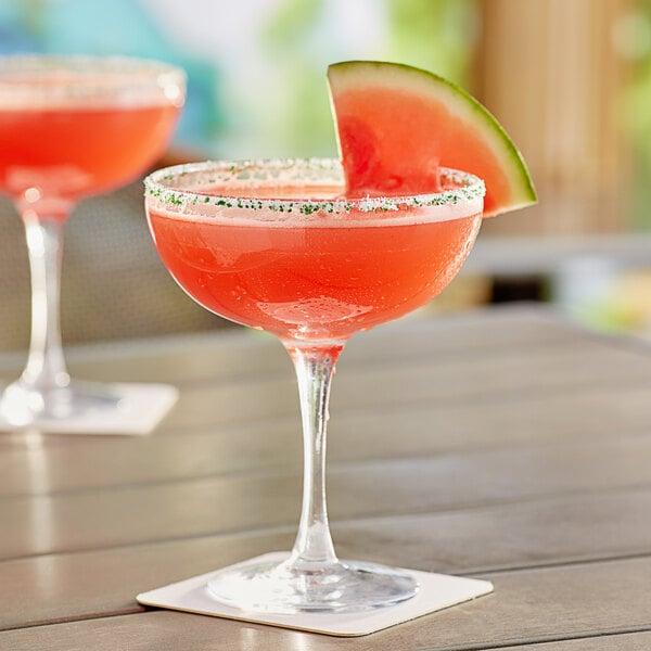 An Acopa margarita glass filled with a red watermelon drink with a sugar rim.