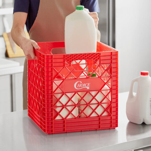 A man holding a milk jug in a red plastic crate.