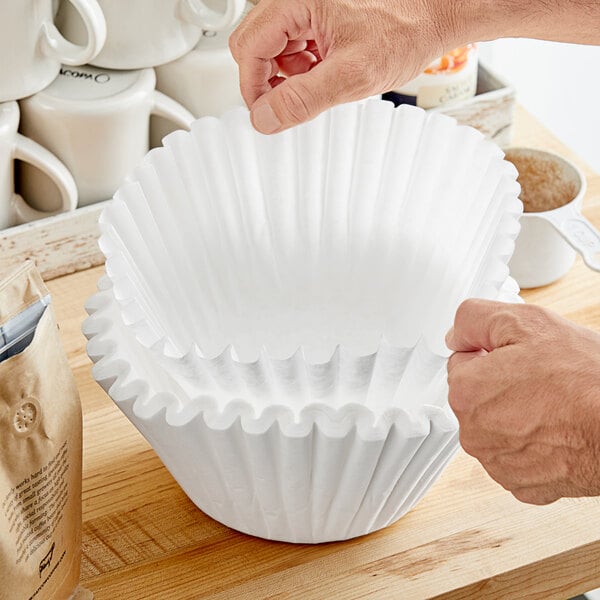 A person putting a Choice coffee filter into a white cup.