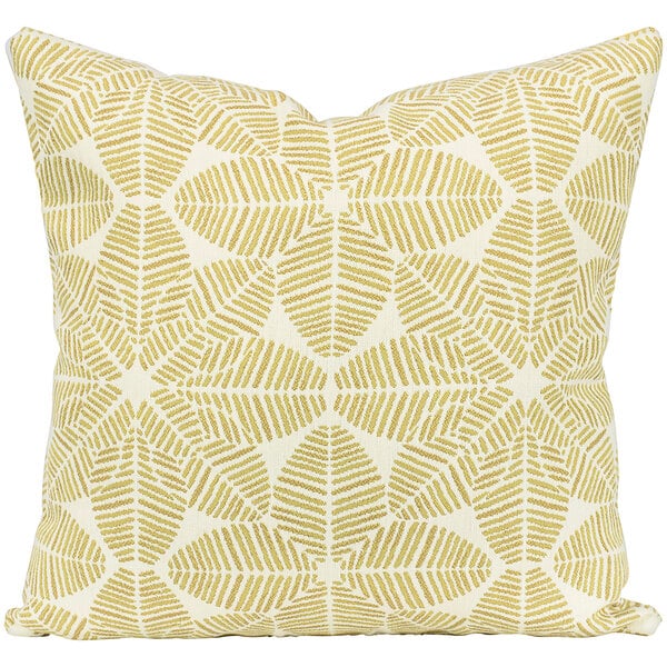 An Astella white and yellow throw pillow with a leaf pattern.
