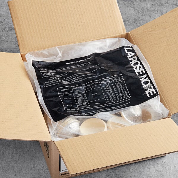 A white box with a black plastic bag of La Rose Noire Unbaked Pastry Shells inside.