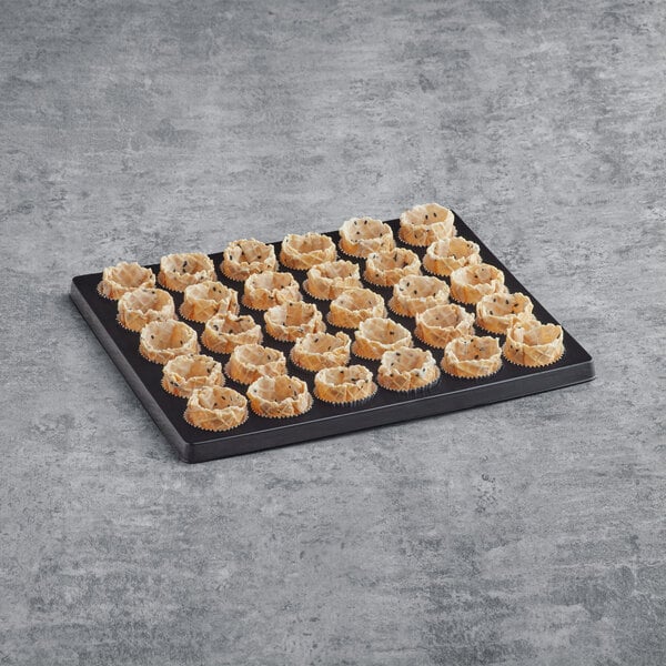 A La Rose Noire black sesame basket shell on a tray on a table in a bakery display.