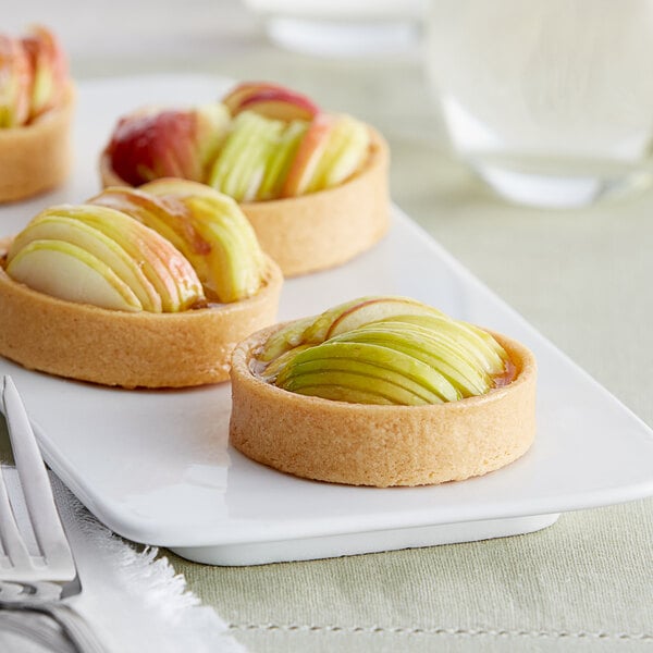 A plate of La Rose Noire medium round vanilla tart shells filled with apple tartlets.