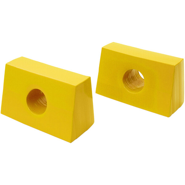 Two yellow plastic blocks with holes in them.