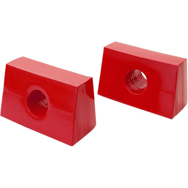 Two red plastic blocks with holes in them.