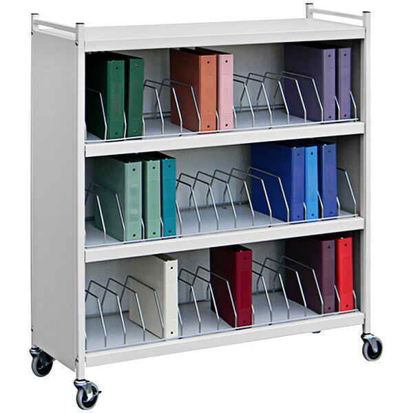 A white metal Omnimed cart with several file holders holding binders.