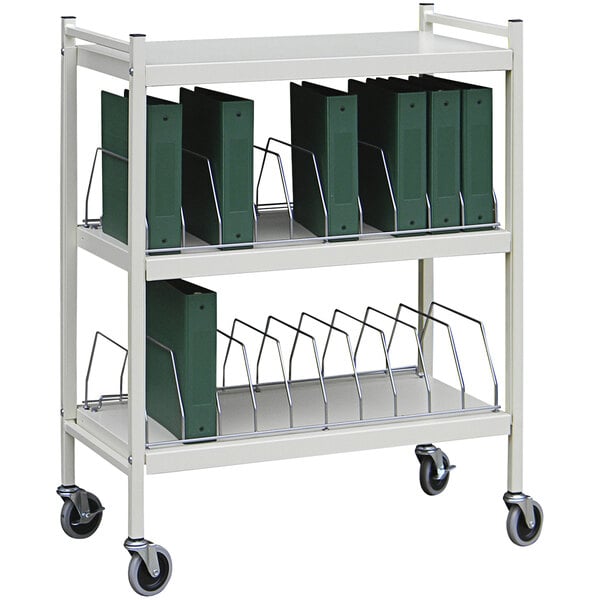 An Omnimed light gray medical cart with green binders on it.