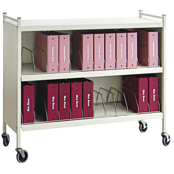 A beige Omnicart medical cart with red binders on it.