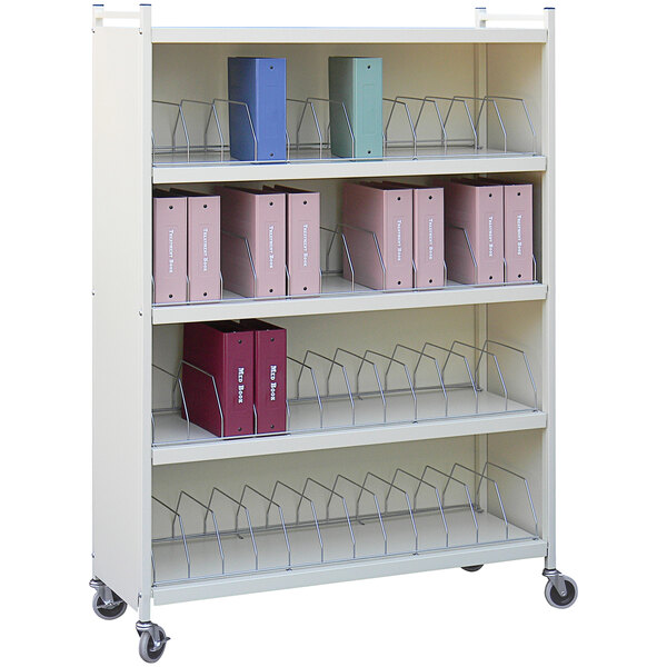 A beige metal Omnimed cart with several red and blue binders on it.
