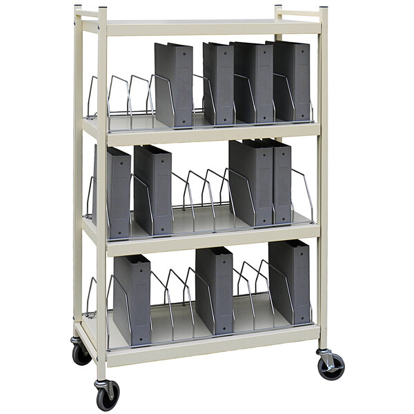 An Omnimed beige metal cart with binders on shelves.