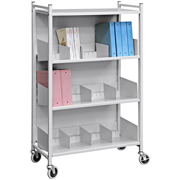 A white Omnimed metal cabinet rack with shelves holding books and pink and blue folders.