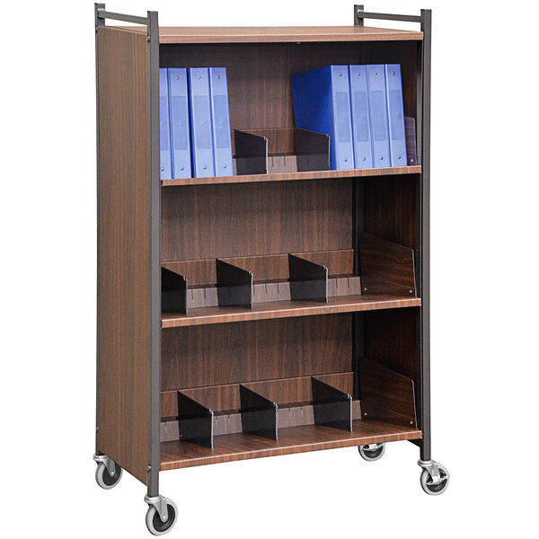 An Omnimed woodgrain cabinet rack with three shelves holding blue folders.