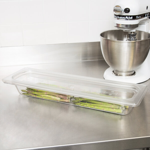 A clear plastic food pan filled with food on a kitchen counter.