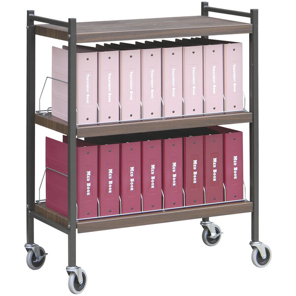 An Omnimed woodgrain medical cart shelf with binders on it.