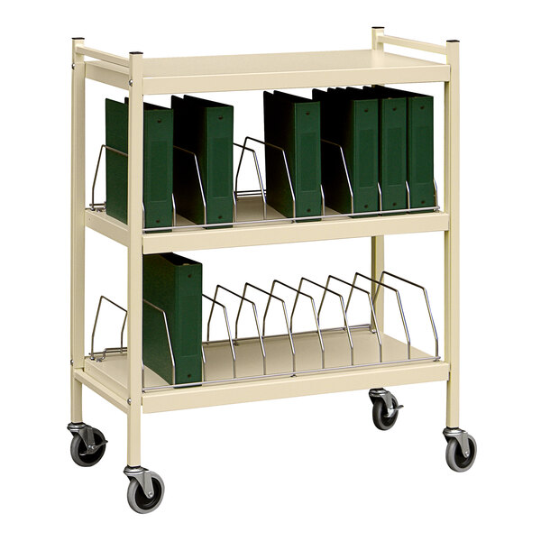 An Omnimed beige medical cart with green binders on it.