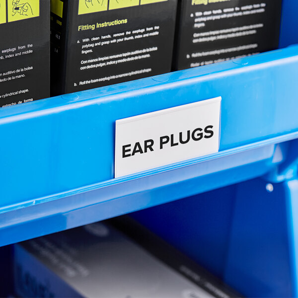 A blue shelf with Regency black and white labels in black and white label holders.