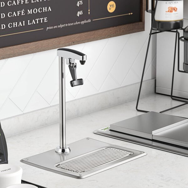 A Regency glass filler station with a silver faucet on a counter.