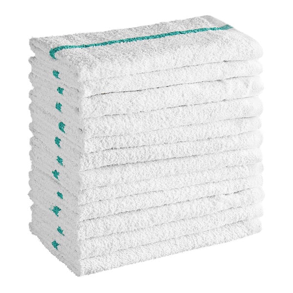 A stack of white textured towels with green stripes along the edges.