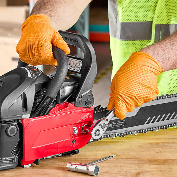 A person wearing Lavex Pro nitrile gloves using a chainsaw.