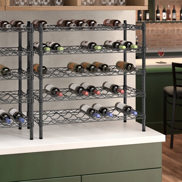 A Regency black epoxy wire wine rack with bottles on it.