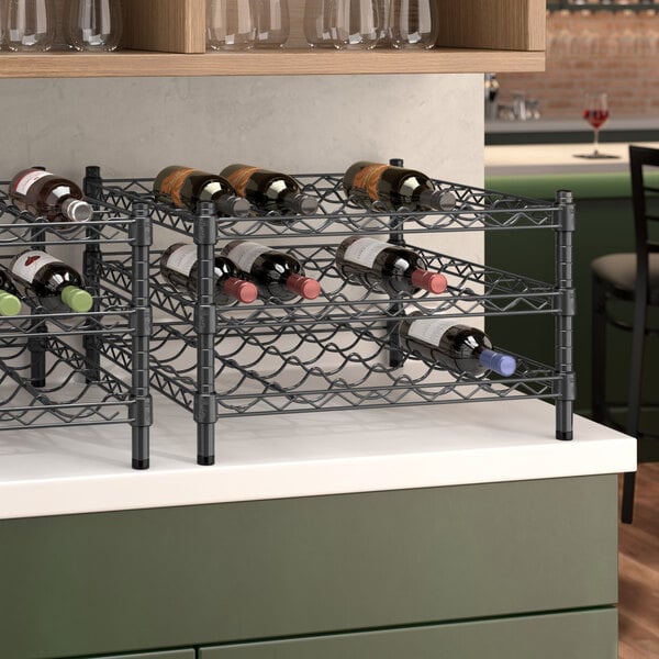 A black Regency wire wine rack on a counter holding bottles of wine.