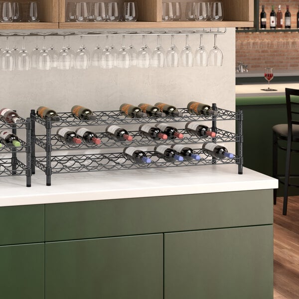 A Regency black wire wine rack on a green counter.