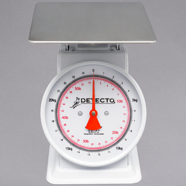 A white scale with a red dial and white base.