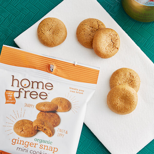 A yellow bag of Homefree Gluten-Free Organic Mini Ginger Snap Cookies on a white surface with cookies spilling out.