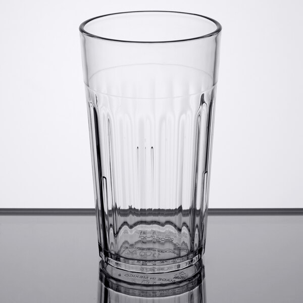 A Carlisle clear plastic tumbler on a white table.