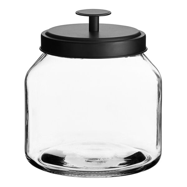 An Acopa Dusk clear glass jar with a black lid on a kitchen counter.