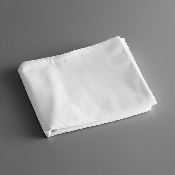 A folded white Intedge tablecloth on a gray surface.