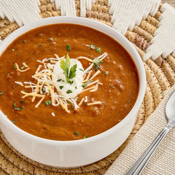 A bowl of Chef Francisco Chuckwagon Chili Soup with cheese and parsley on top.