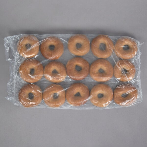 A whole wheat bagel in plastic wrap.