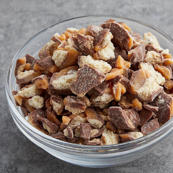 A bowl of TWIX® chocolate and caramel candy on a table.