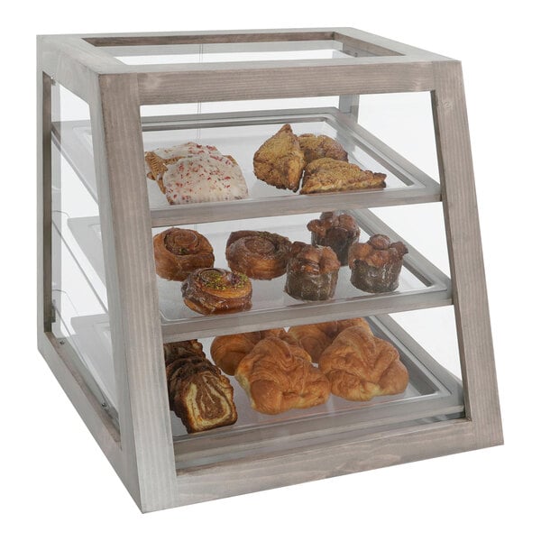 A Cal-Mil slanted bakery display case with various pastries on it.