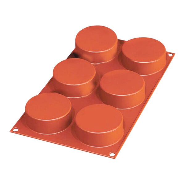 A red silicone baking mold with six round cylinder cavities.