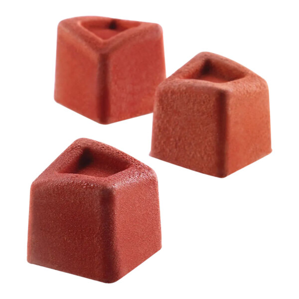 A close-up of a Silikomart Mini Cube silicone baking mold with red cubes inside.