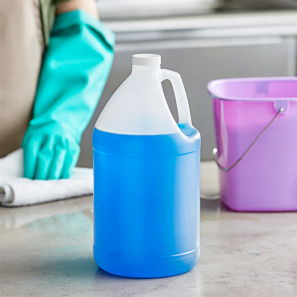 A translucent HDPE jug filled with blue liquid next to a blue bucket.