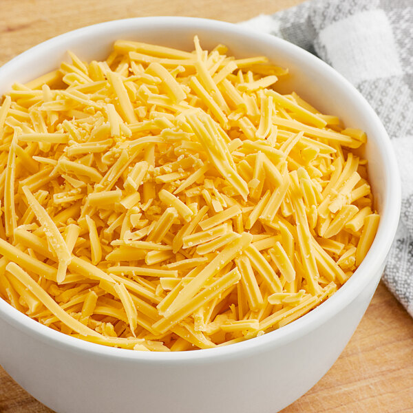 A bowl of Violife Just Like Cheddar vegan cheese shreds.