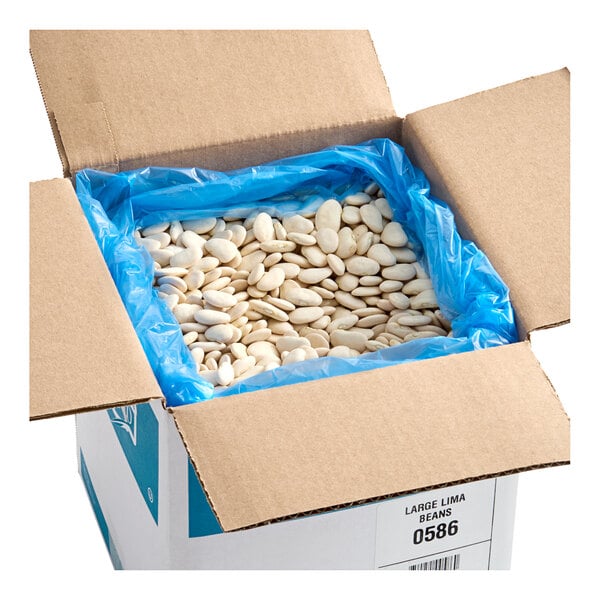 A cardboard box containing dried large lima beans lined with a blue plastic bag.