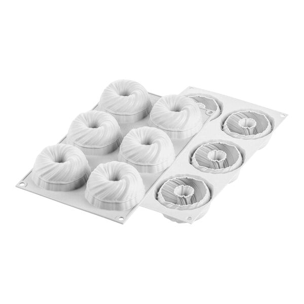 A white Silikomart silicone baking mold with six curved spiral cavities.