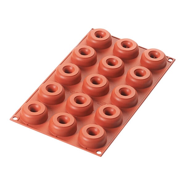 A red silicone baking mold with 15 mini donut cavities.